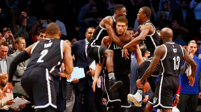Brook Lopez #11 of the Brooklyn Nets is mobbed by...