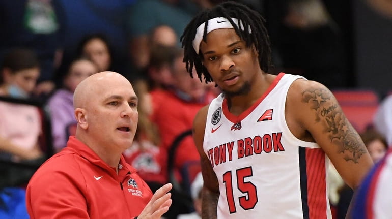 Stony Brook coach Geno Ford talks to guard Anthony Roberts in...