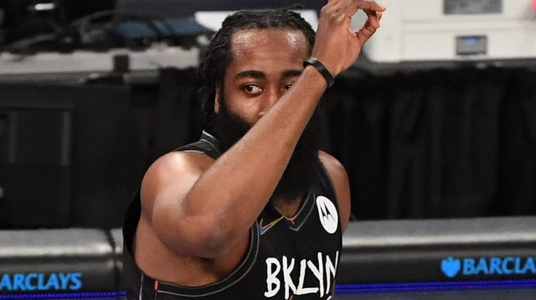 Nets guard James Harden gestures after sinking a three-point basket...