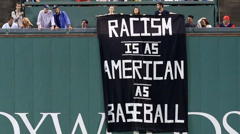 A banner with the message "Racism is as American as...