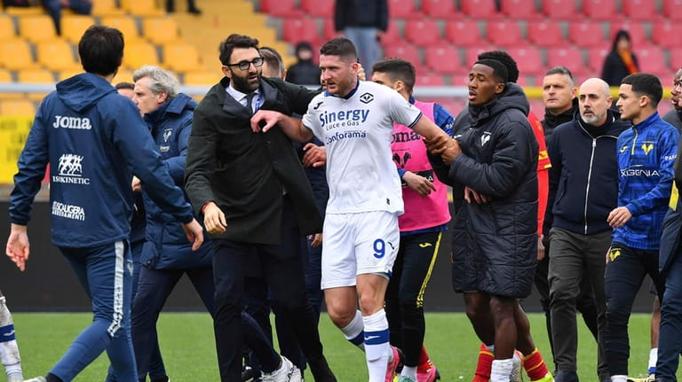 Verona's Thomas Henry, center, leaves the pitch after the Serie...
