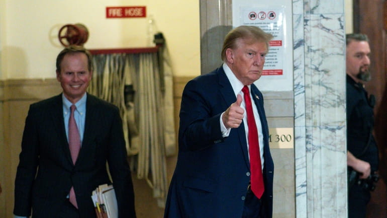 Former President Donald Trump gives a thumbs up as he...