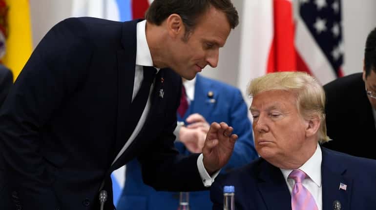 French President Emmanuel Macron speaks with President Donald Trump before...
