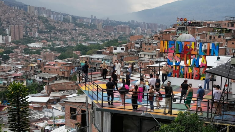 Tourists take photos in the Comuna 13 neighborhood of Medellin,...