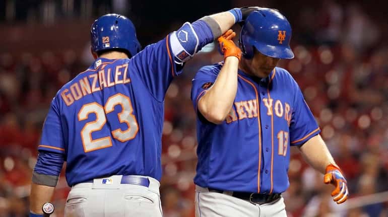 The Mets' Jay Bruce, right, is congratulated by teammate Adrian...
