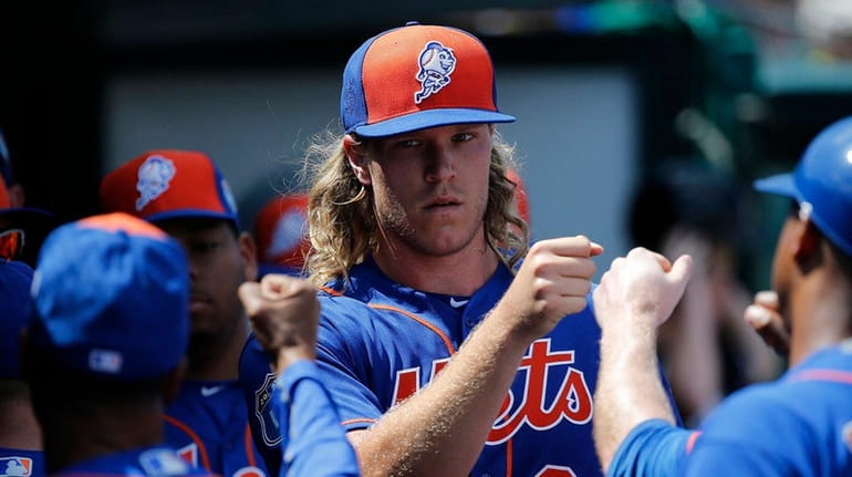 New York Mets starting pitcher Noah Syndergaard, center, is greeted...
