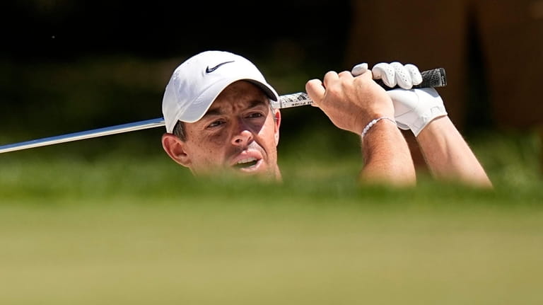 Rory McIlroy watches his bunker shot on the eighth hole...