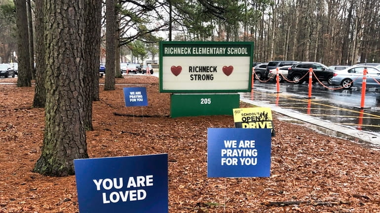 Signs stand outside Richneck Elementary School in Newport News, Va.,...