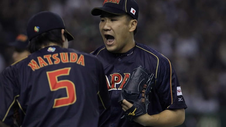 Pitcher Masahiro Tanaka of Japan reacts after the seventh inning...