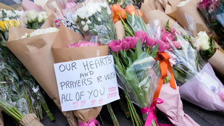 A note is left with flower tributes near a crime...