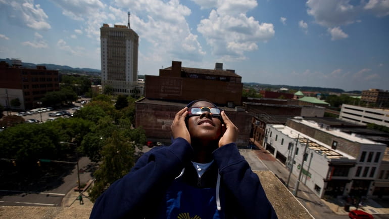 Justin Coleman, of Birmingham, Ala., holds his glasses up to...