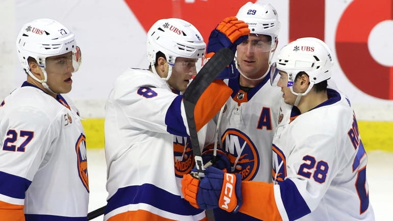New York Islanders defenseman Noah Dobson celebrates his goal with teammates...
