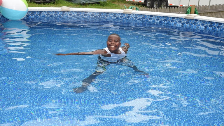 Nine-year-old Harlem Brown enjoying his family's pool at home in...