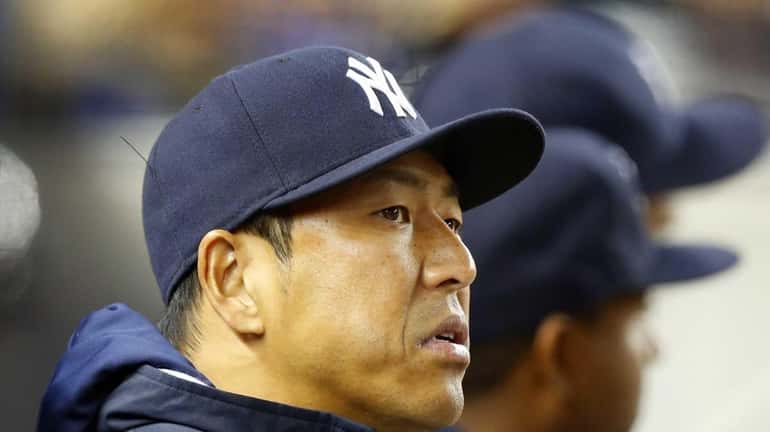 Hiroki Kuroda of the Yankees looks on from the dugout...