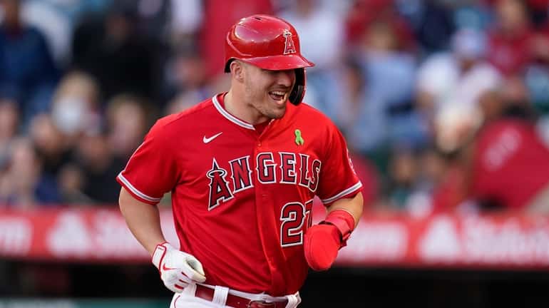 Los Angeles Angels' Mike Trout (27) runs to the dugout...