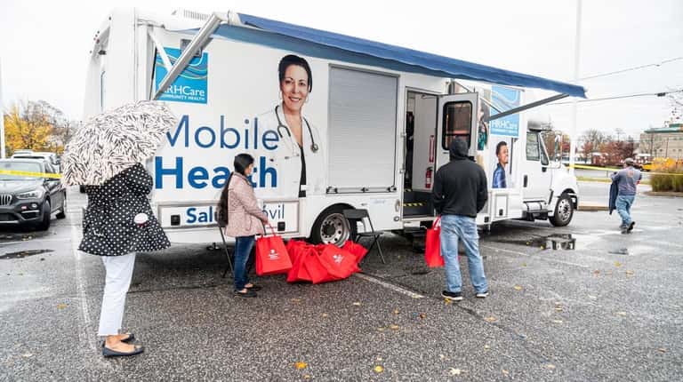 A mobile health vehicle parked outside the Riverhead Free Library...