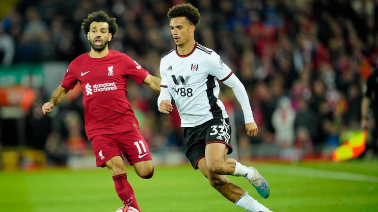 Liverpool's Mohamed Salah, left, challenges for the ball with Fulham's...