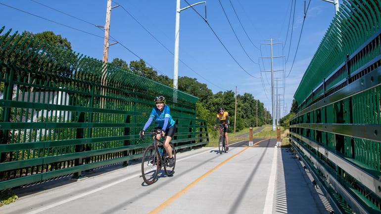 Cyclists cross an overpass at the North Shore Rail Trail...