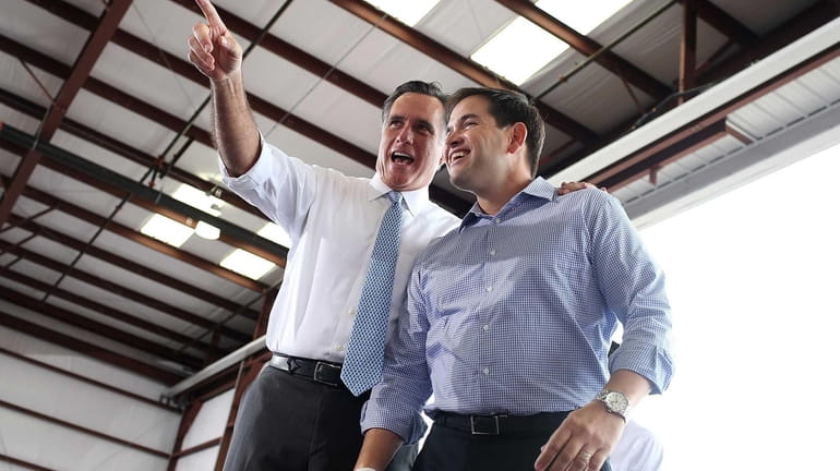 Mitt Romney, left, and Sen. Marco Rubio (R-FL) greet supporters...