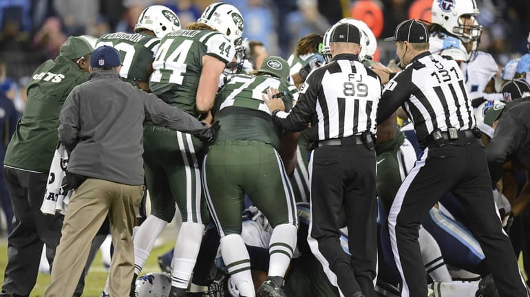 Officials try to break up a fight between players in...