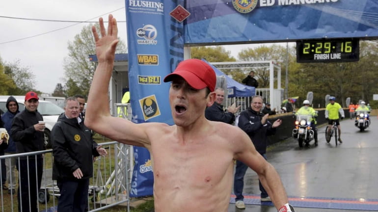 Oz Pearlman, winner of the 26.2-mile marathon, crosses the finish...