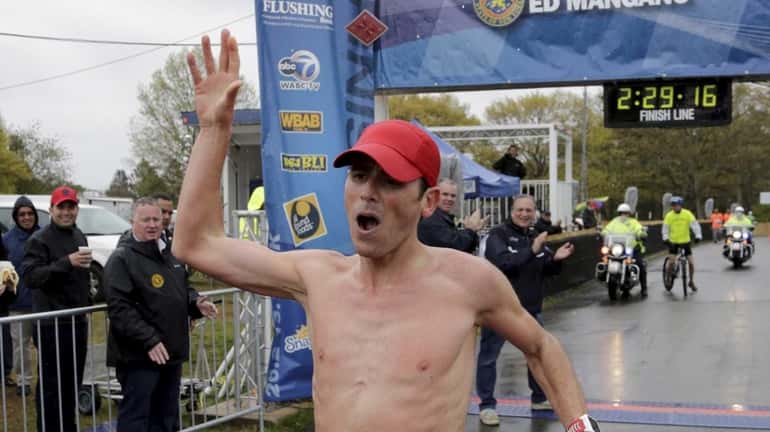 Oz Pearlman, winner of the 26.2-mile marathon, crosses the finish...