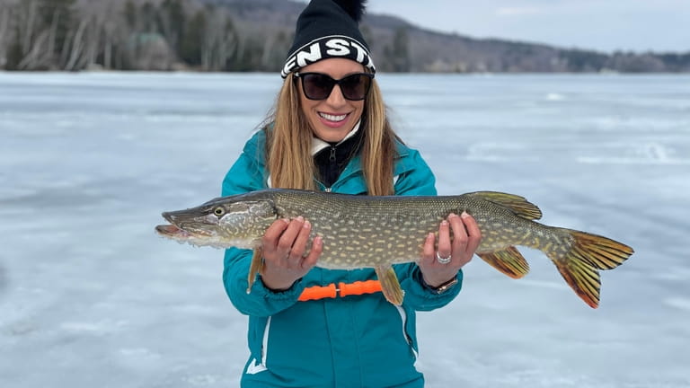 A participant in an ice fishing session with Catamount Fishing...