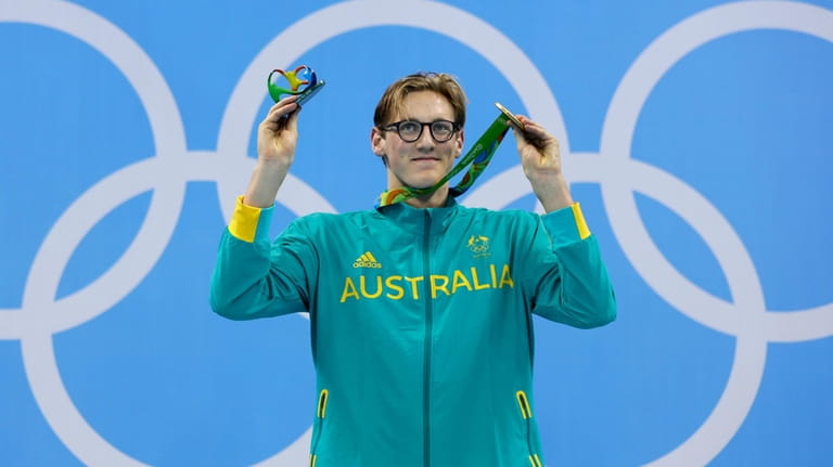 Australia's gold medal winner Mack Horton celebrates on the podium...