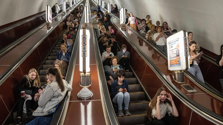 People take cover at a metro station during a Russian...