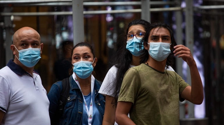 People wear a face masks in Manhattan on Thursday.