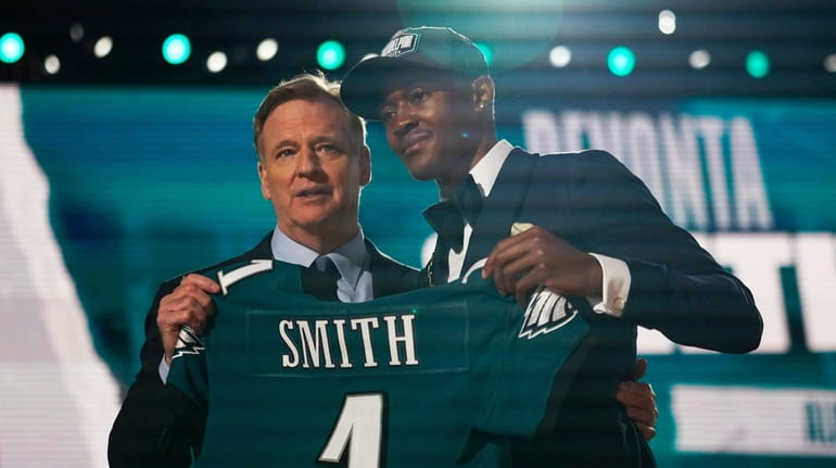 Alabama wide receiver DeVonta Smith, right, holds an Eagles jersey with...