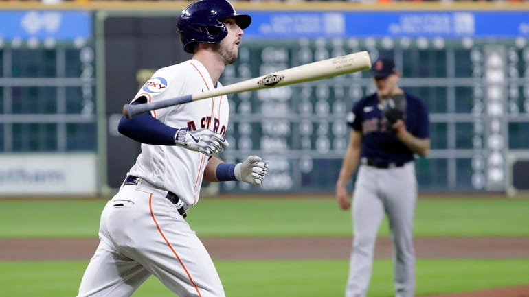 Houston Astros' Kyle Tucker, left, flips his bat as he...
