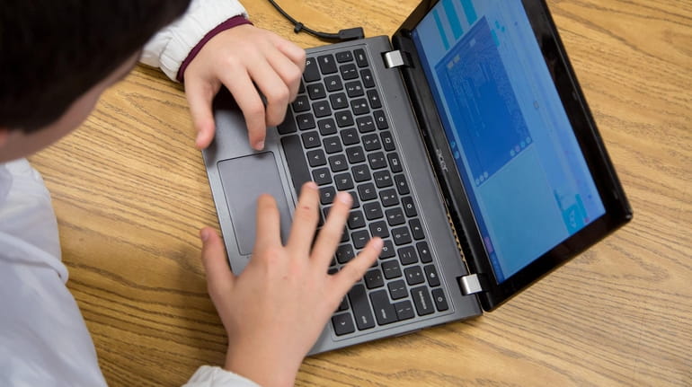 Students use Chromebooks in a class at Elwood Middle School...