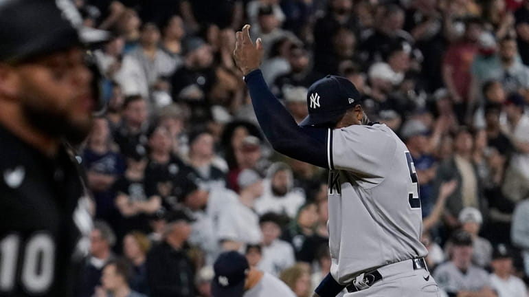 Yankees relief pitcher Aroldis Chapman, right, wipes his face as...