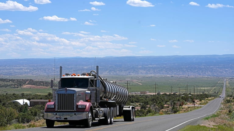 A tanker truck transports crude oil on a highway near...