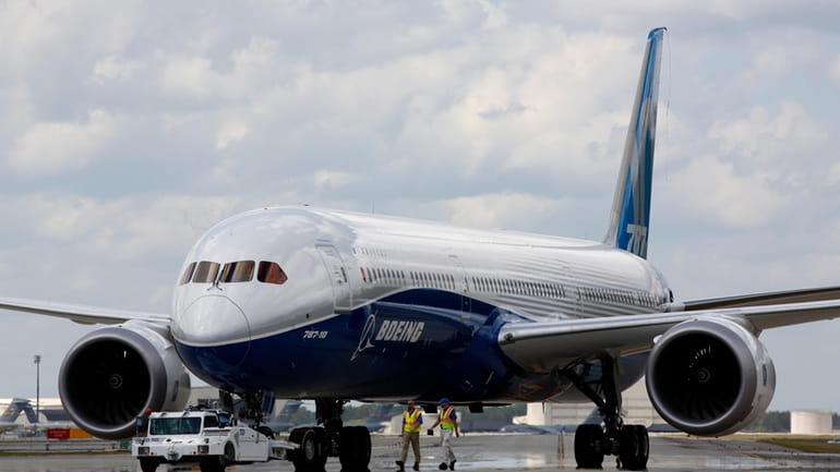 Boeing employees walk the new Boeing 787-10 Dreamliner down towards...