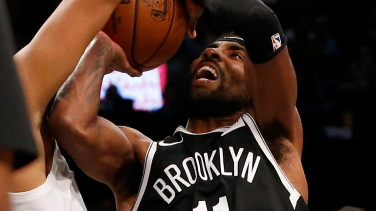 Kyrie Irving of the Nets attempts a shot in the...