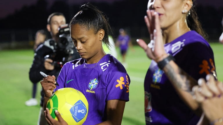 Brazil's Ary Borges signs a ball belonging to Caboolture Sports...