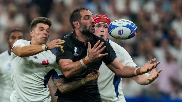 New Zealand's Samuel Whitelock, center, fights for the ball with...