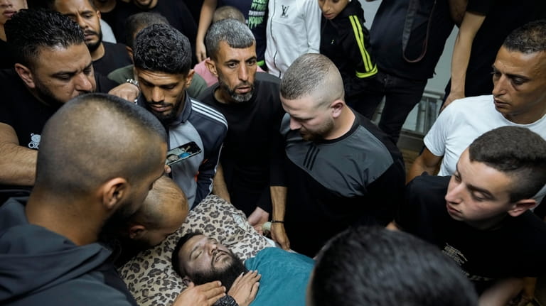 Relatives take a last look at the body of Palestinian...