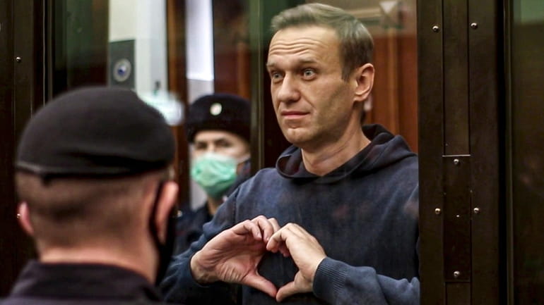 Russian opposition leader Alexei Navalny shows a heart symbol while...