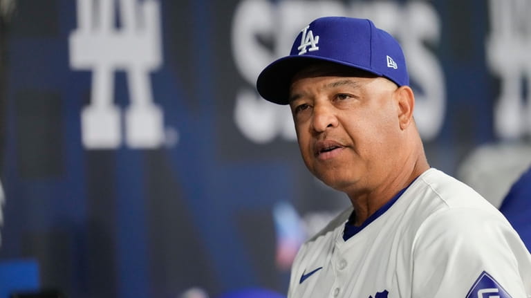 Los Angeles Dodgers' manager Dave Roberts talks with team players...