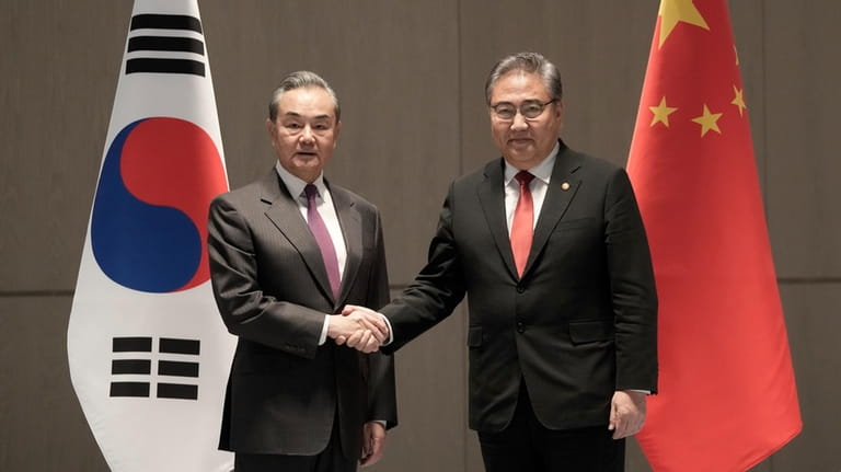 South Korean Foreign Minister Park Jin, right, shakes hands with...