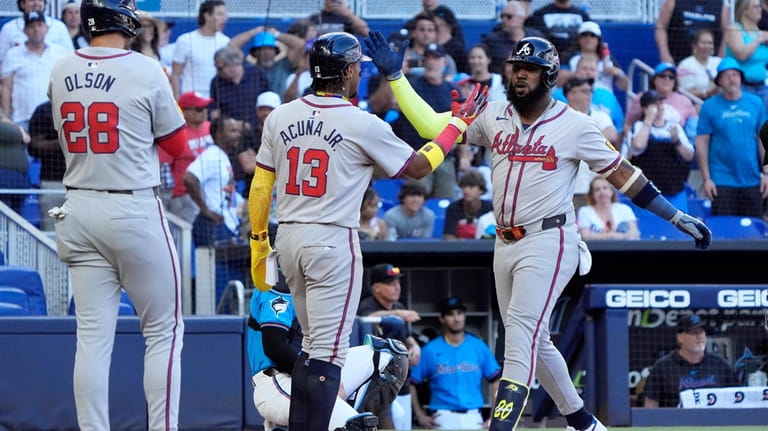 Atlanta Braves' Marcell Ozuna, right, is congratulated by teammates after...