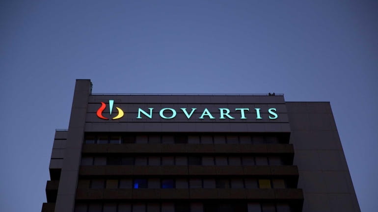 An illuminated logo sits above windows at Novartis AG's headquarters...