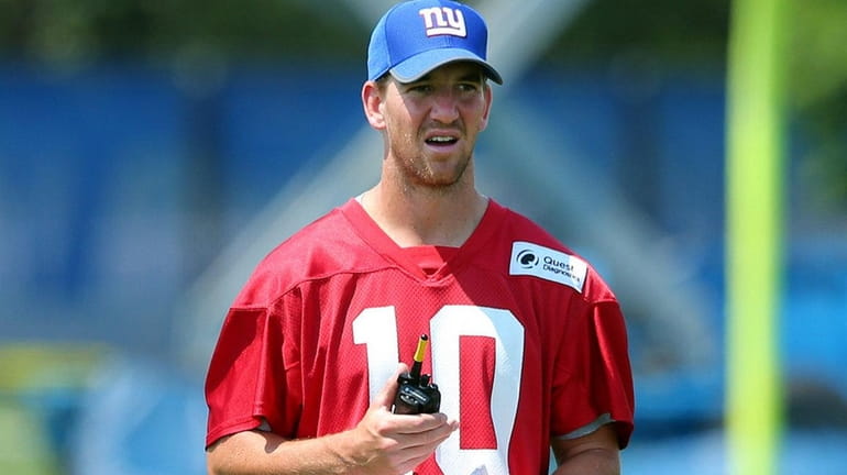 Giants quarterback Eli Manning watches practice from the sidelines during...
