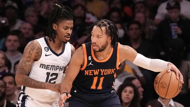 Jalen Brunson of the Knicks is guarded closely by Ja Morant...