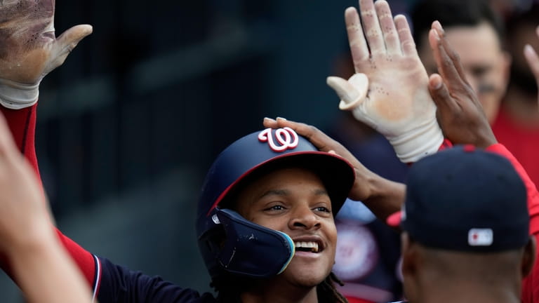 Washington Nationals' CJ Abrams (5) celebrates in the dugout after...