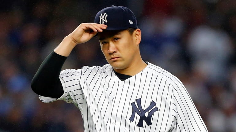 Masahiro Tanaka of the New York Yankees walks to the...