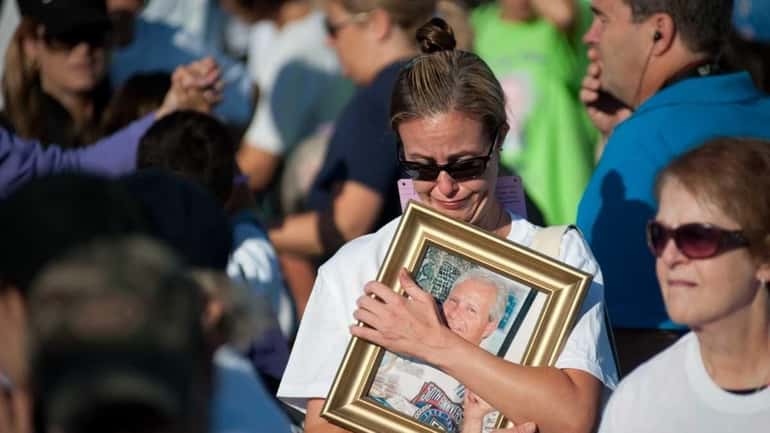 Stacey Melillo of Hauppauge hugs a photograph of her dad....